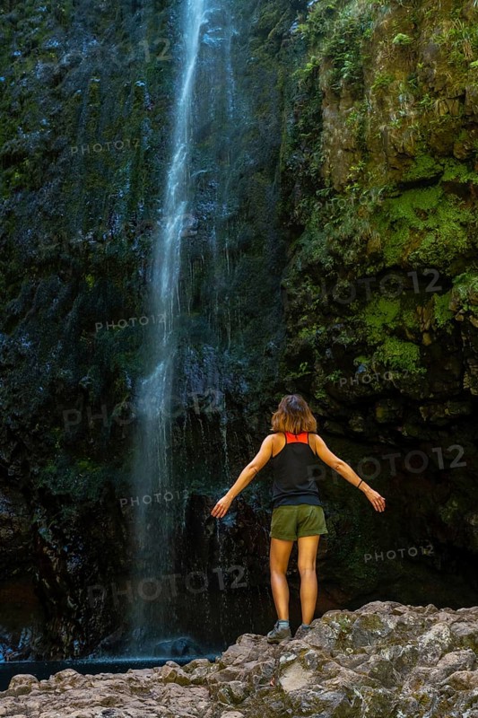 A young woman at the impressive waterfall at the Levada do Caldeirao Verde