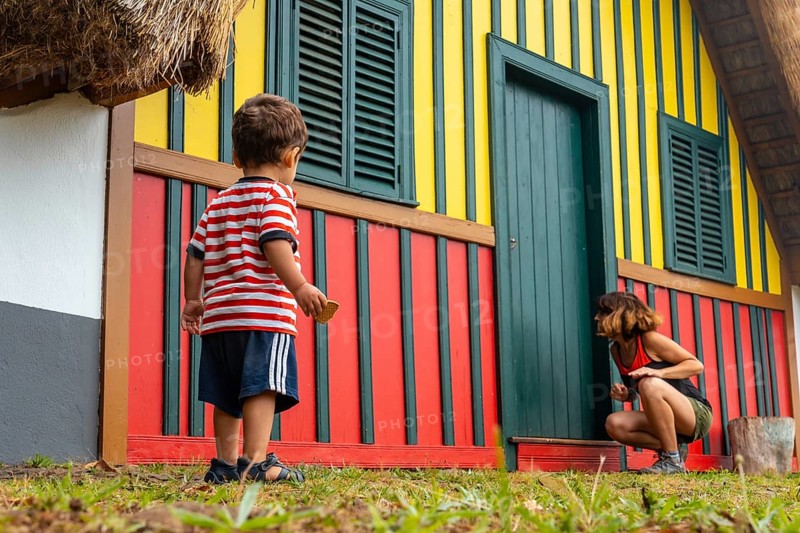 Mother and son playing in a traditional Madeiran house like the ones in Santana in the forest of Caldeirao Verde