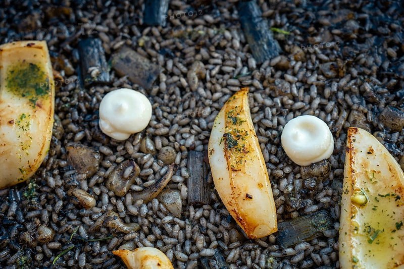 Detail of the black rice with cuttlefish and young garlic with aioli