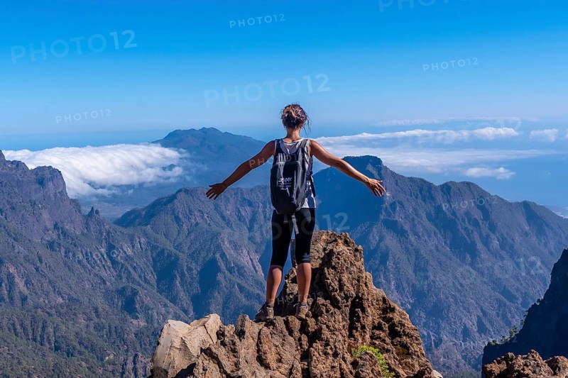 A young woman looking out from the top of the Caldera de Taburiente volcano near Roque de los Muchachos one summer afternoon