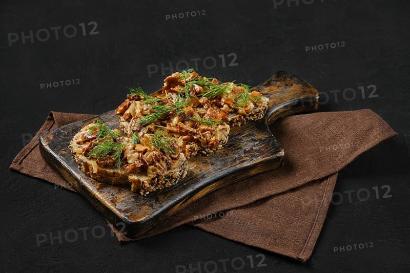 Sandwich with chanterelle mushrooms on black background