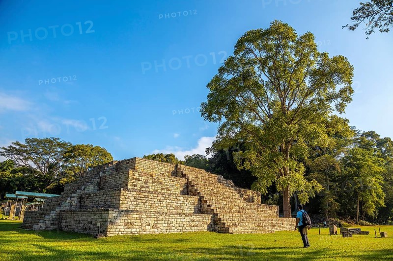 A young man watching A Mayan pyramid at The Copan Ruins temples. Honduras