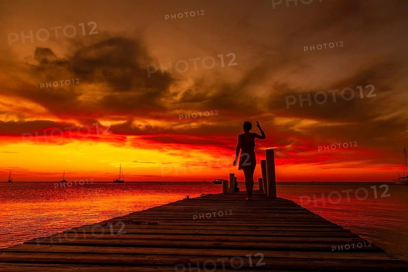 A young woman walking in the sunset on West End beach in Roatan