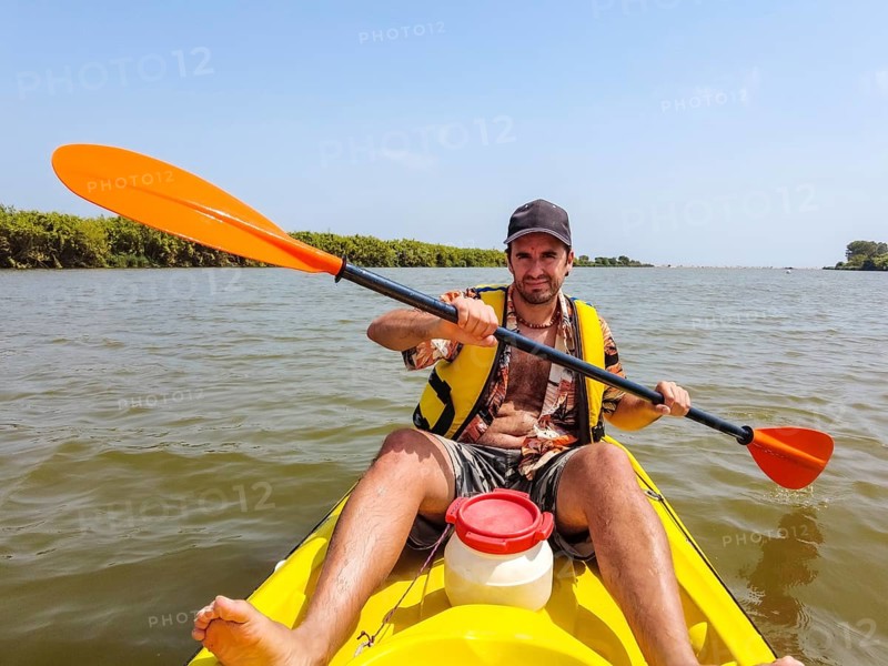 A young man in the canoe doing canoeing in the a natural park of Catalonia