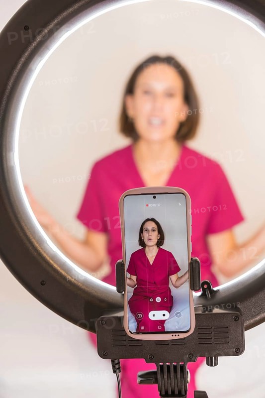 Vertical photo of a nutritionist woman filming video with the mobile phone