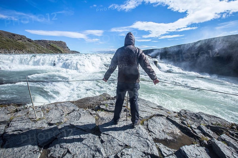A young man above the Gullfoss waterfall in the golden circle of the south of Iceland