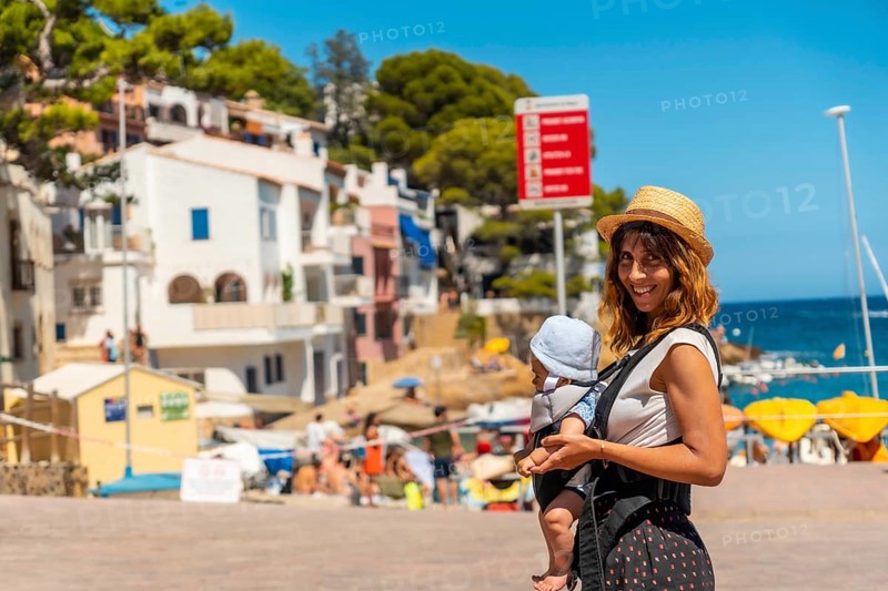 A mother with her baby on the beach of Sa Tuna on the coast of Begur in summer
