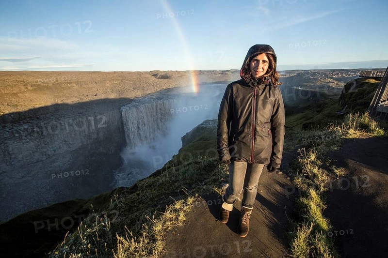 A young woman looking at the Dettifoss Waterfall