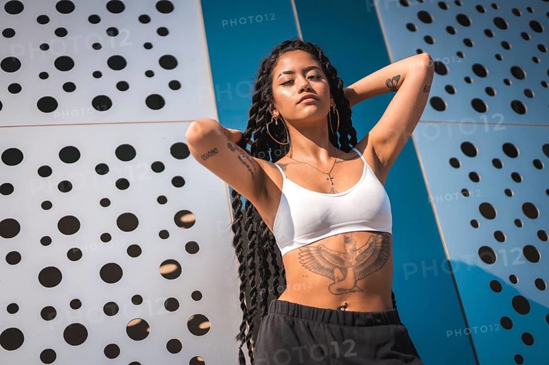 Young woman of black ethnicity with long braids and tattoos