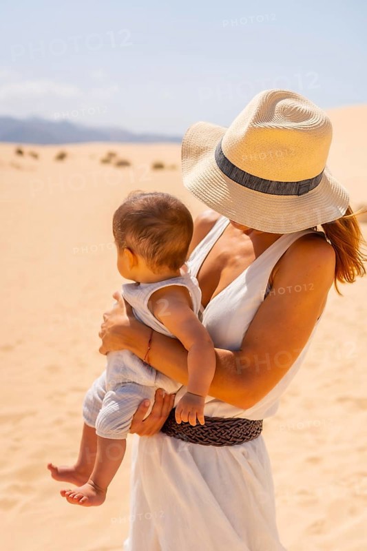 Pretty young mother with her son on vacation in the dunes of the Corralejo Natural Park