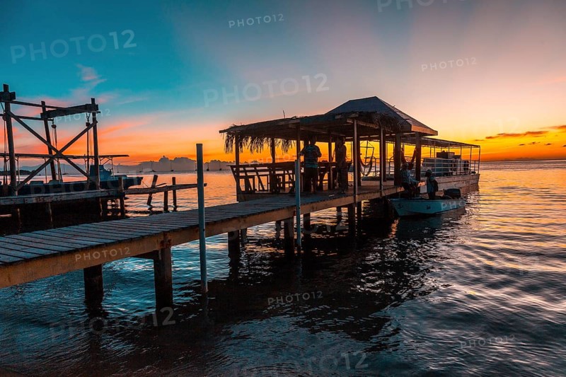 A pier and the boat in the background on a beach on Roatan Island. Honduras