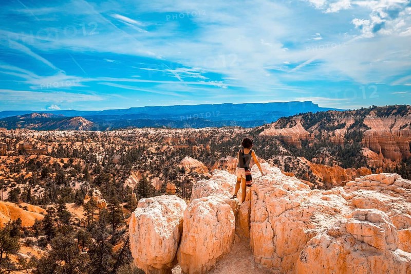 A girl sitting looking at the views from the Sunrise Point in Bryce National Park. Utah