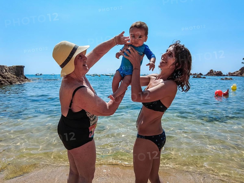 A family having fun in the summer in Cala Canyet next to the town of Tossa de Mar. Girona