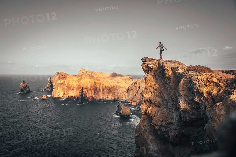 A young man in Ponta de Sao Lourenco on the coast with rock formations
