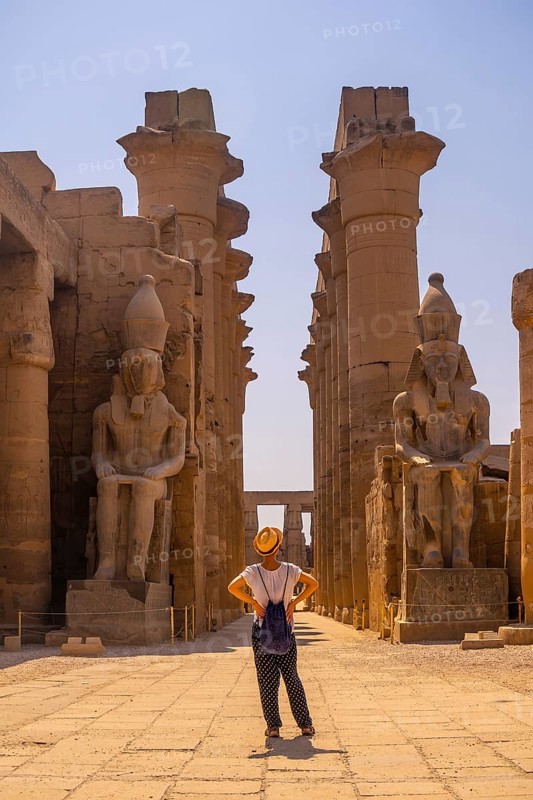 A young tourist with a hat visiting the Egyptian Temple of Luxor and its beautiful columns. Egypt