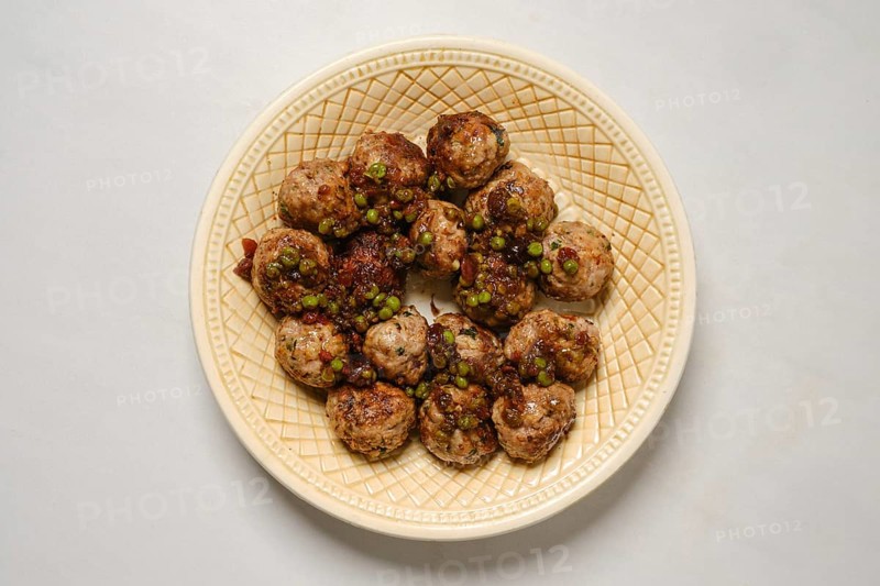 Top view of plate with minced meat meatballs with green pea and cranberry jam