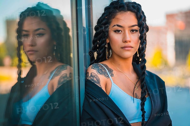 Urban session. Young woman of black ethnicity with long braids and with tattoos