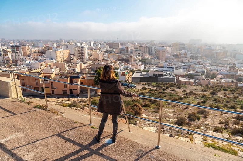 A young tourist girl looking at the city from the Cerro San Cristobal viewpoint in the city of Almeria