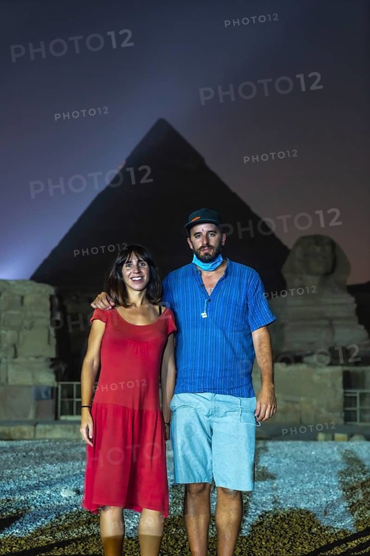 A tourist couple at the sound and light show at the beautiful pyramids and sphinx of Giza. Night in the city of Cairo. Africa