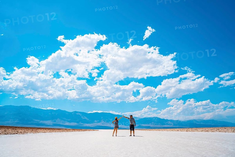 A couple of tourists walking in the white salt flat of Badwater Basin