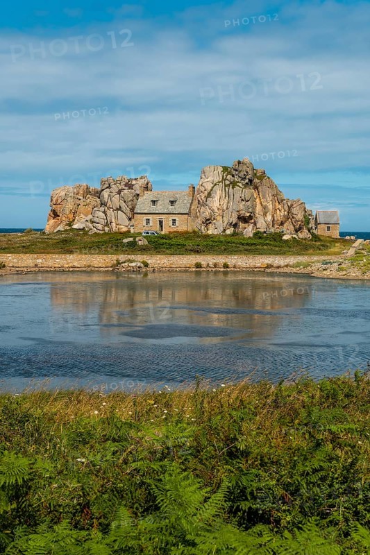 House among rocks next to a beautiful lake