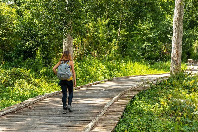 A young woman on the footpath along a footbridge between La Garette and Coulon