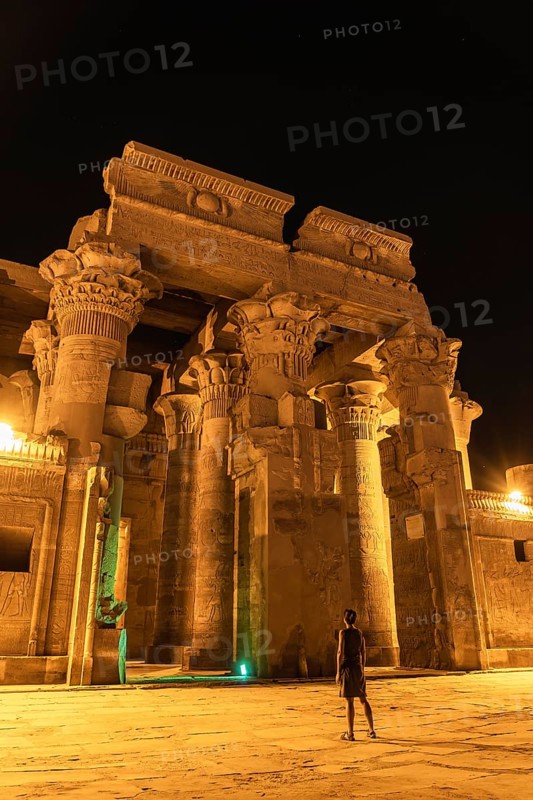 A young woman visiting at night the beautiful temple of Kom Ombo