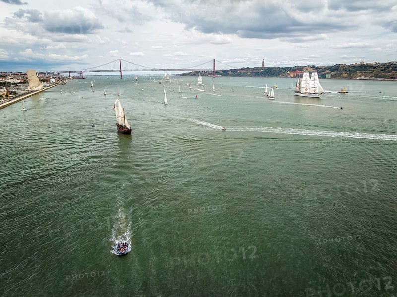 Aerial drone view of tall ships with sails sailing in Tagus river towards the Atlantic ocean in Lisbon