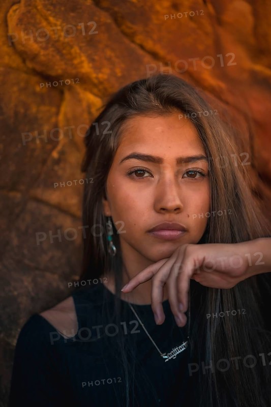 A young pretty brunette Latina with long straight hair in a short black T-shirt and pink pants. Portrait of the girl in a close-up shot