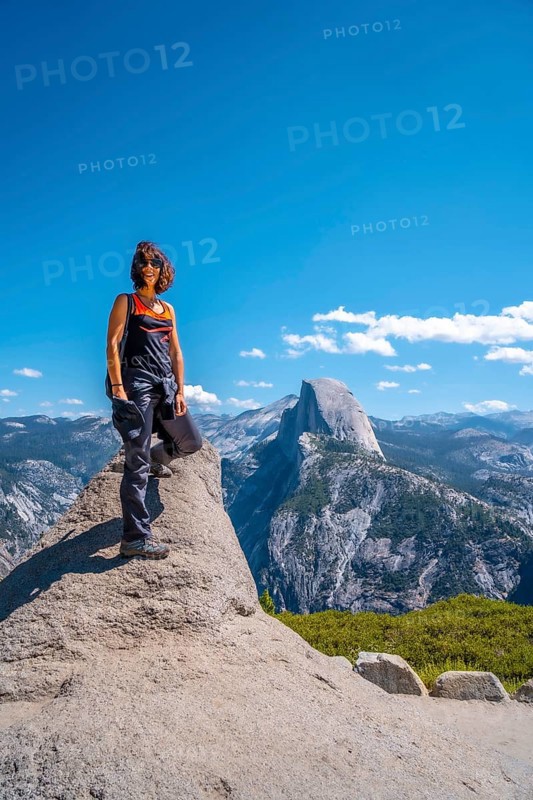 A young woman in pink and black at the Glacier point on the Half Dome wall. Yosemite National Park