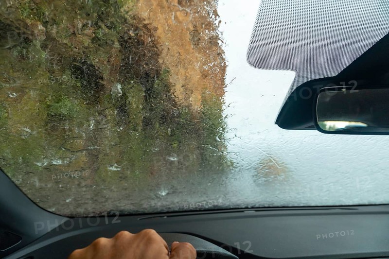 Water on top of the car driving inside a car at Anjos Waterfall