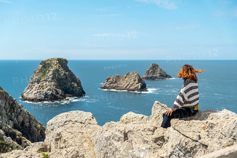 A young tourist girl looking at the sea at Pen Hir Point on the Crozon Peninsula in French Brittany