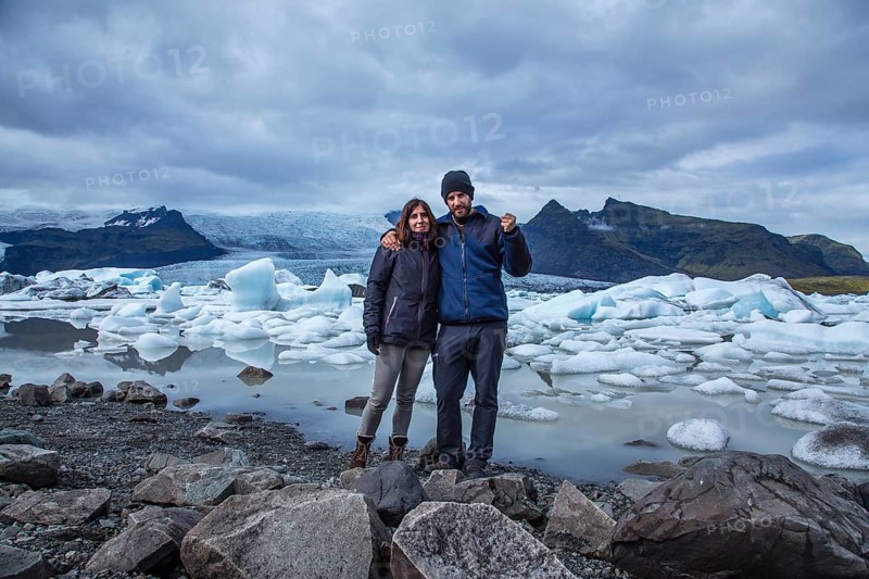 A couple with a backpack looking at the Jokulsarlon Ice Lake in the golden circle of southern Iceland