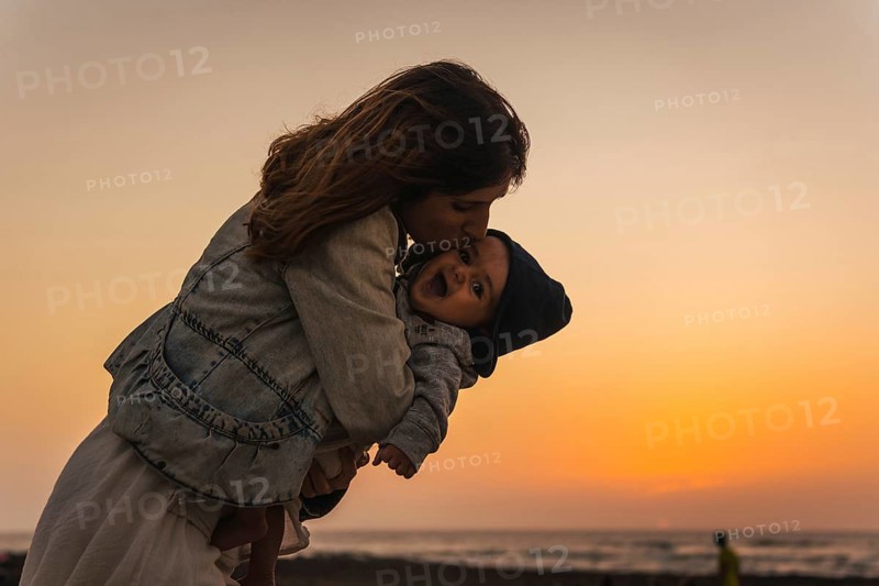 A young mother kissing her son at the Toston Lighthouse Sunset