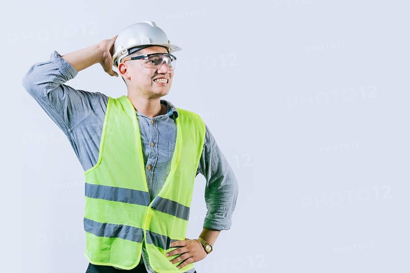 Worried builder engineer holding his head isolated. Troubled young engineer holding his head looking up. Worried male engineer man holding his head
