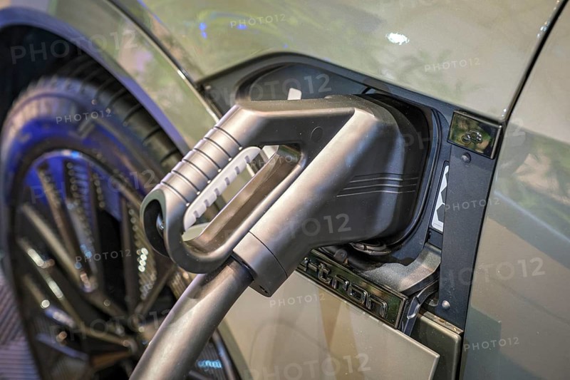 Charging port socket plug in modern electric vehicle EV car close up with charging cable. Environment ecology alternative green renewable clean sustainable energy zero emission concept
