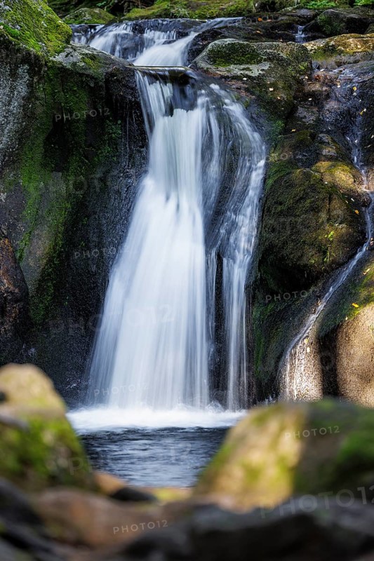 Waterfall in autumn forest with rocks