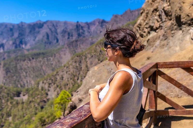 A young tourist looking at the landscape at the Mirador de los Roques on the La Cumbrecita mountain on the island of La Palma next to the Caldera de Taburiente