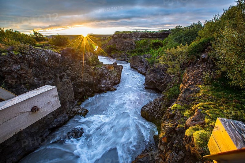 Gorgeous sunset on the wooden bridge of the Barnafoss river