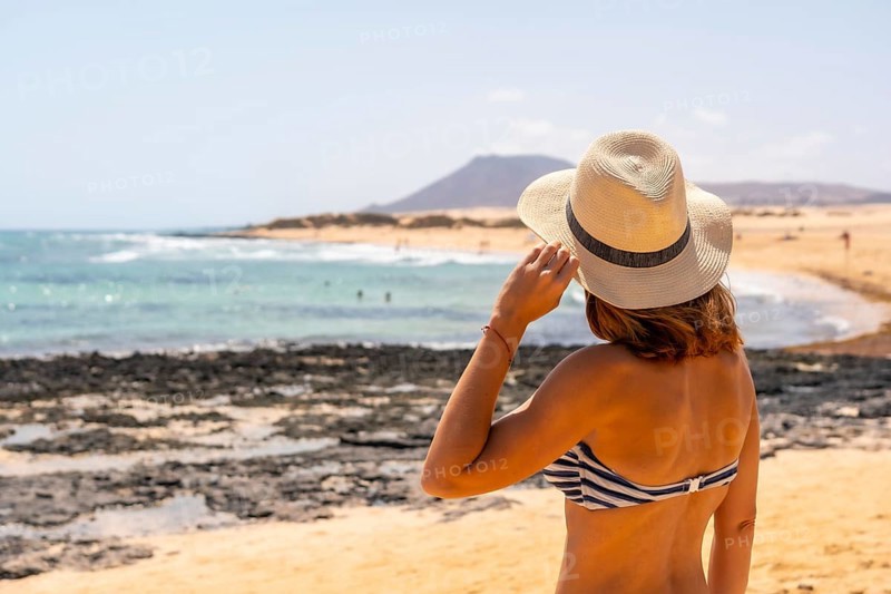 A young tourist with a hat on the beaches of the Corralejo Natural Park
