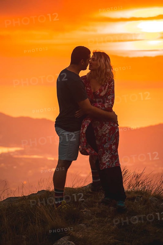 Parents with their son on top of a mountain at sunset