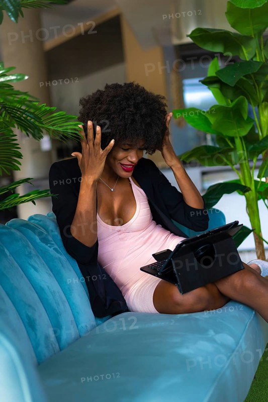 Young entrepreneur of black race and afro hair making a video call with great joy and amazement