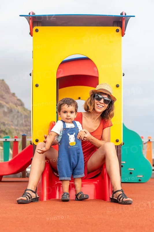 Baby playing in a playground having fun in summer