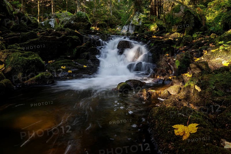 Waterfall in autumn forest with rocks