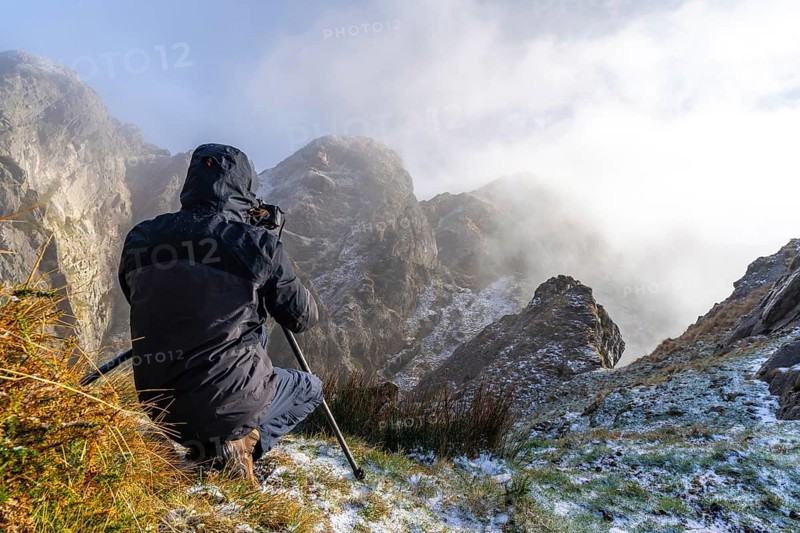 A photographer taking a photo with the tripod in the snowy winter sunset