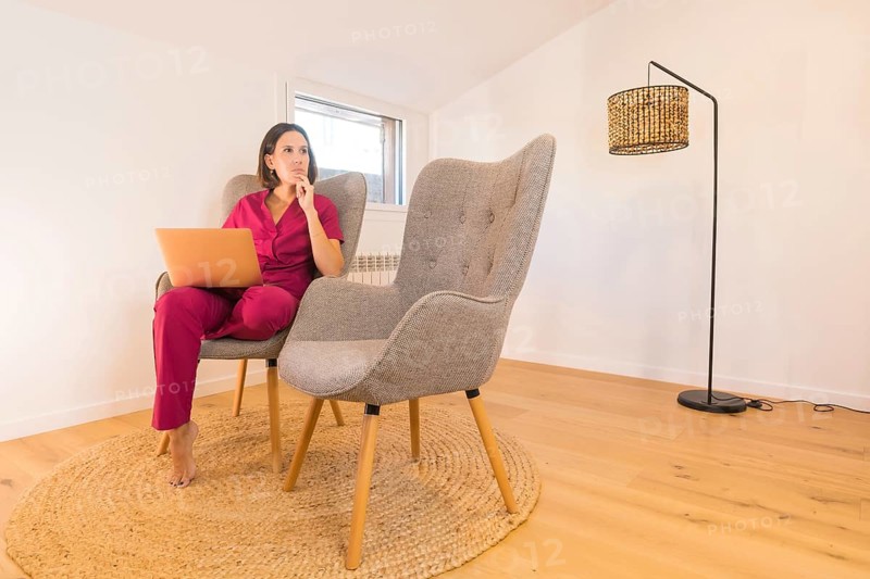 Nutritionist working from home sitting on a couch in a minimalist room
