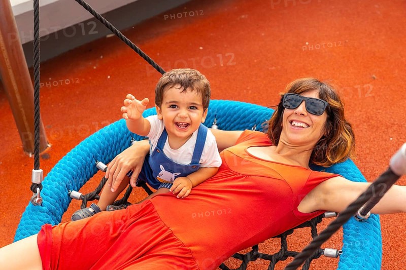 Baby playing in a playground having fun in summer