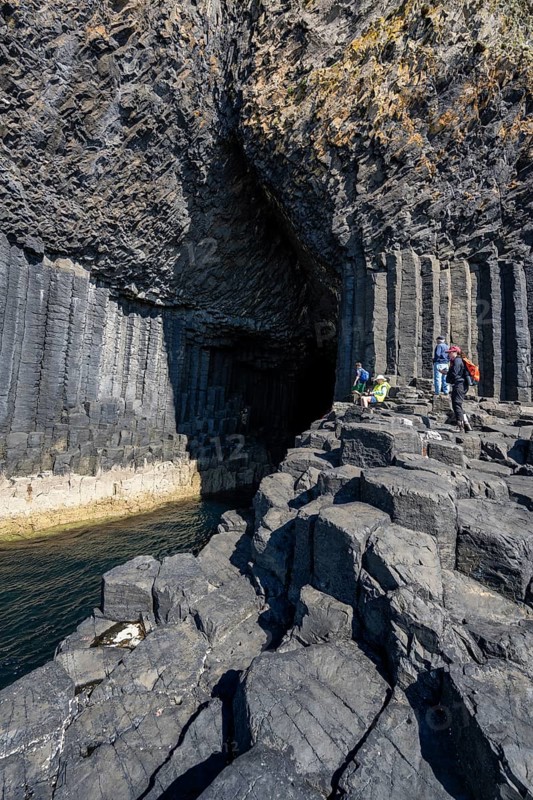 Tourists at the entrance to the 80 metre long and 10 metre wide Fingal's Cave on the uninhabited rocky island of Staffa