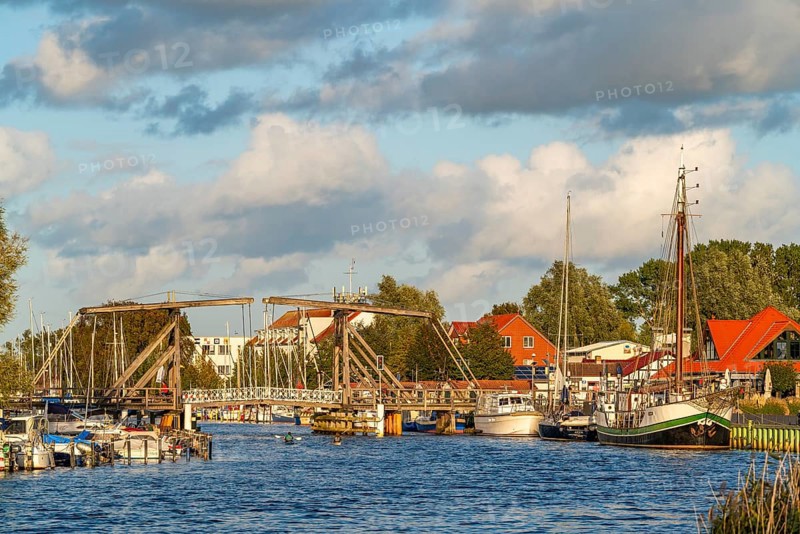 Historic Wieck wooden bascule bridge over the river Ryck and sailing ships in the harbour of the fishing village Wieck