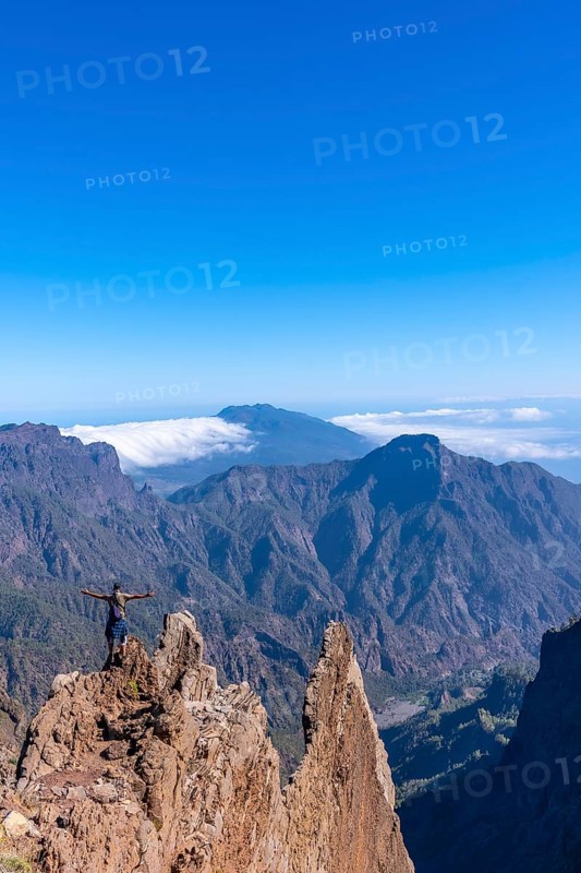 A young man after finishing the trek at the top of the volcano of Caldera de Taburiente near Roque de los Muchachos looking at the incredible landscape